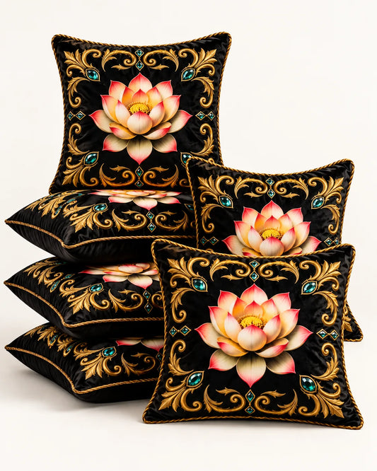 Black cushion covers featuring pink and gold lotus flowers, ornate golden scrollwork, turquoise accents and gold piping.