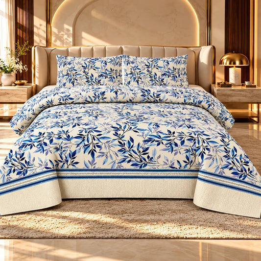 White bedsheet with navy blue, royal blue and lavender botanical leaf prints, decorative blue border and two matching pillow covers on a luxury bed.