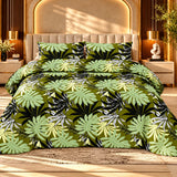 Tropical green bedsheet featuring large light green and olive leaves on a black background with two matching pillow covers on a luxury bed.